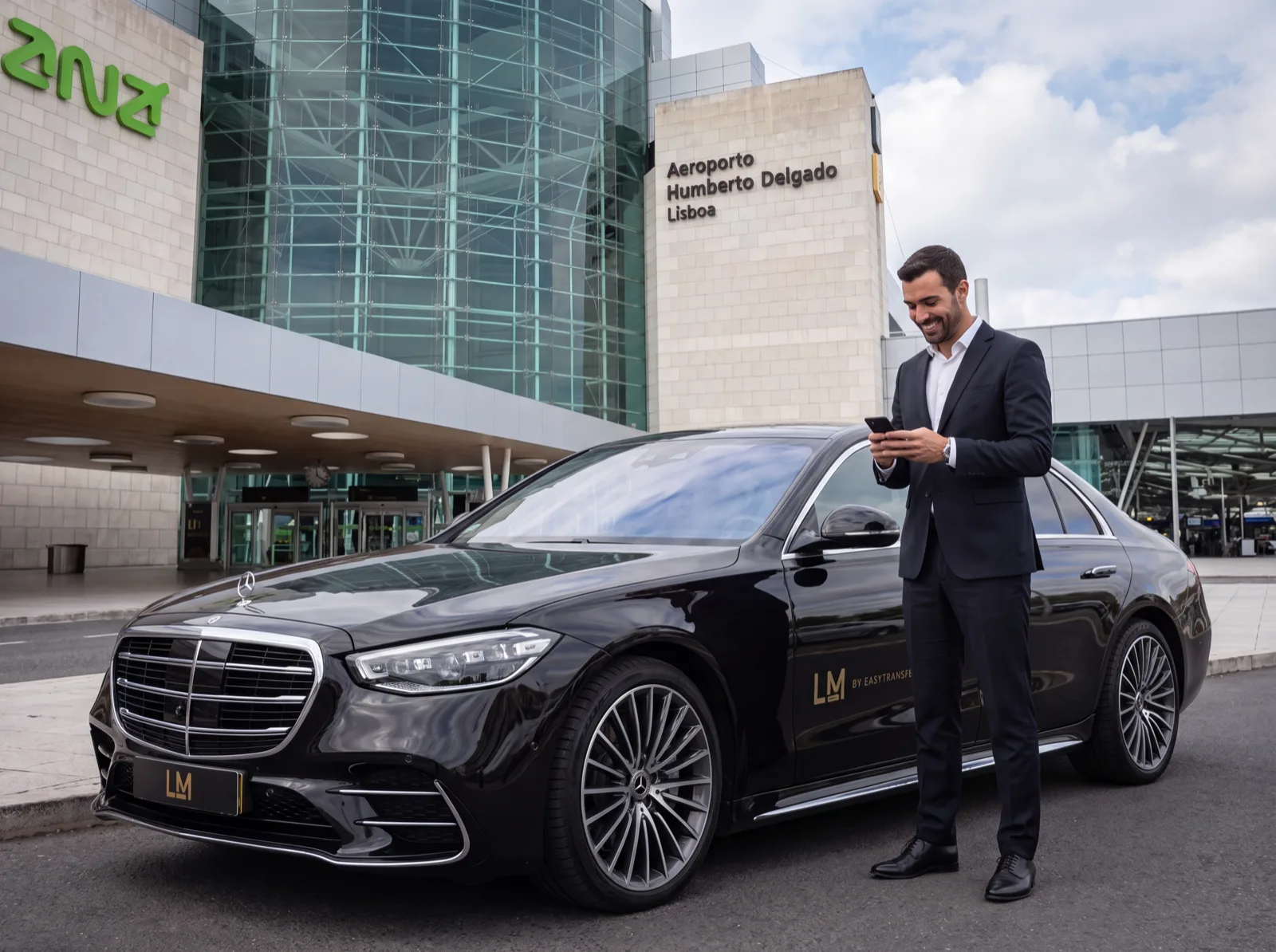 Chauffeur beside a Mercedes S-Class outside Lisbon Airport